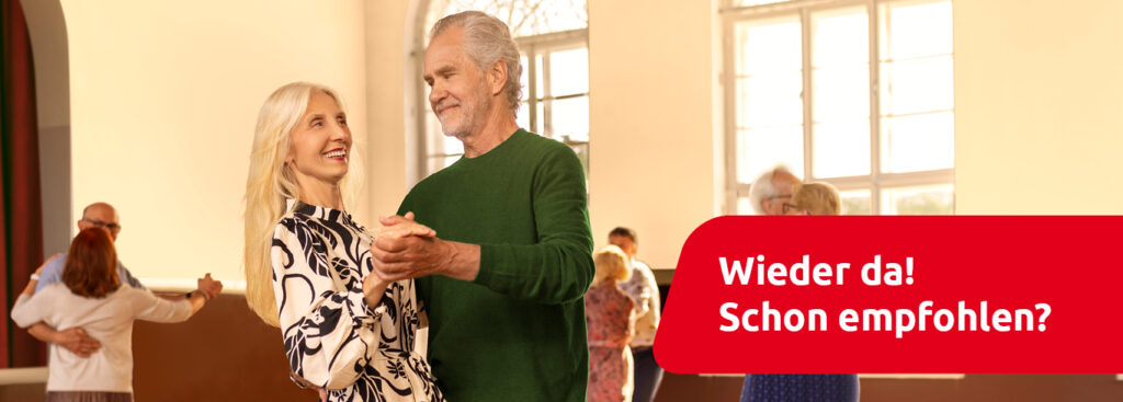 Ein älteres Paar, dass Hand-in-Hand in einem Ball -Saal tanzt. Im Hintergrund sieht man weitere ältere Paare, die ebenfalls tanzen. Im unteren rechten Abschnitt steht in weiß auf rotem Hintergrund „Wieder da! Schon empfohlen?“